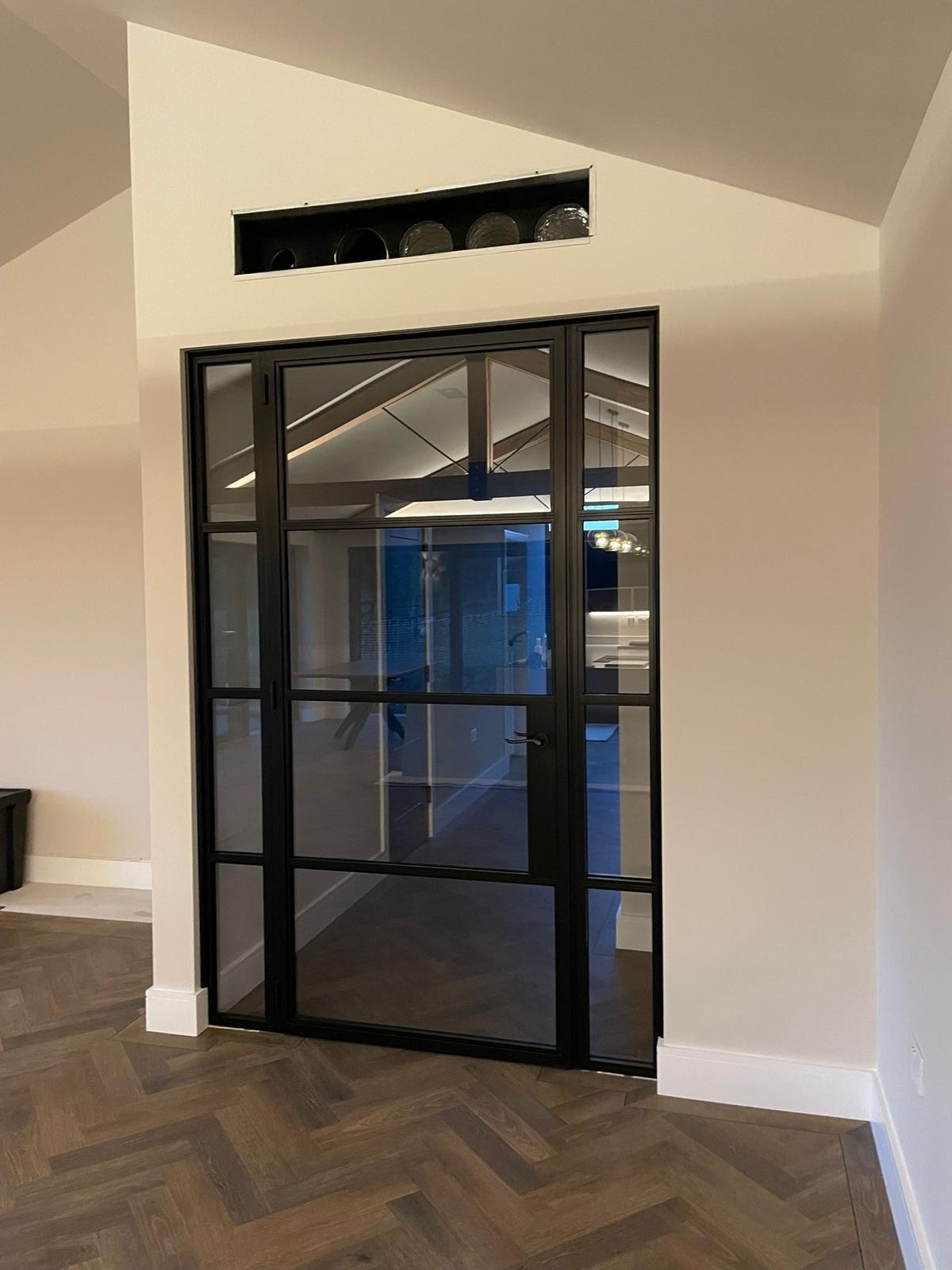 Black framed glazed interior door with herringbone flooring